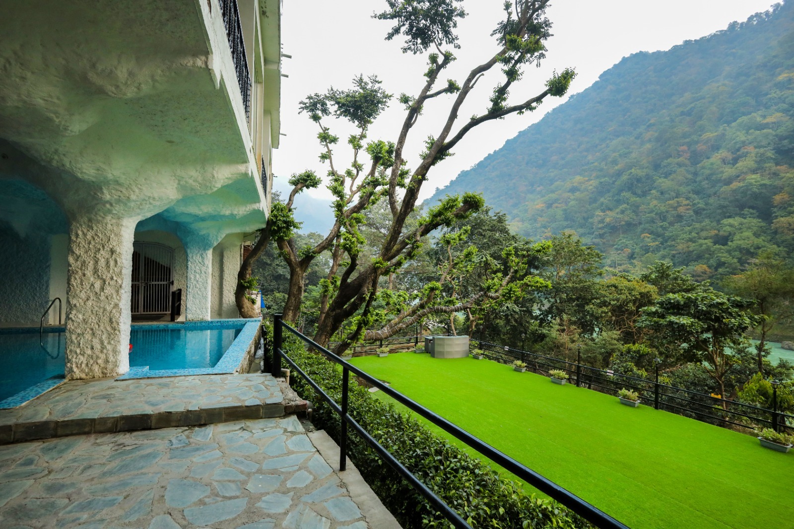 Outdoor swimming pool and green lawn facing the mountains