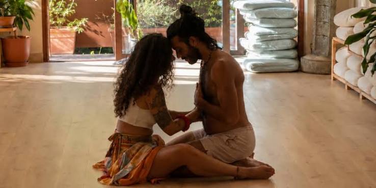 A couple sitting forehead to forehead in a partner practice