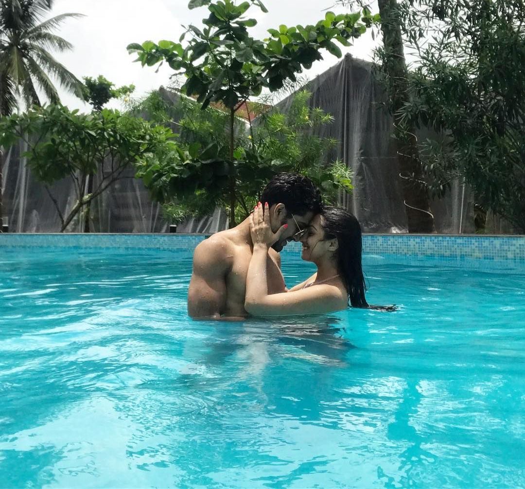 Couple standing close together in a resort swimming pool