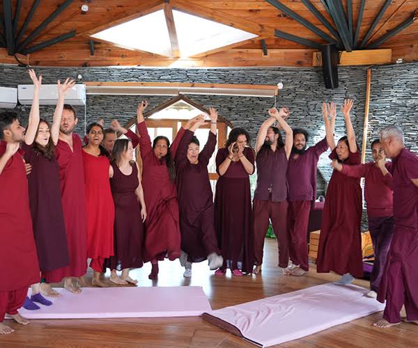 Group standing with hands raised during a joyful session